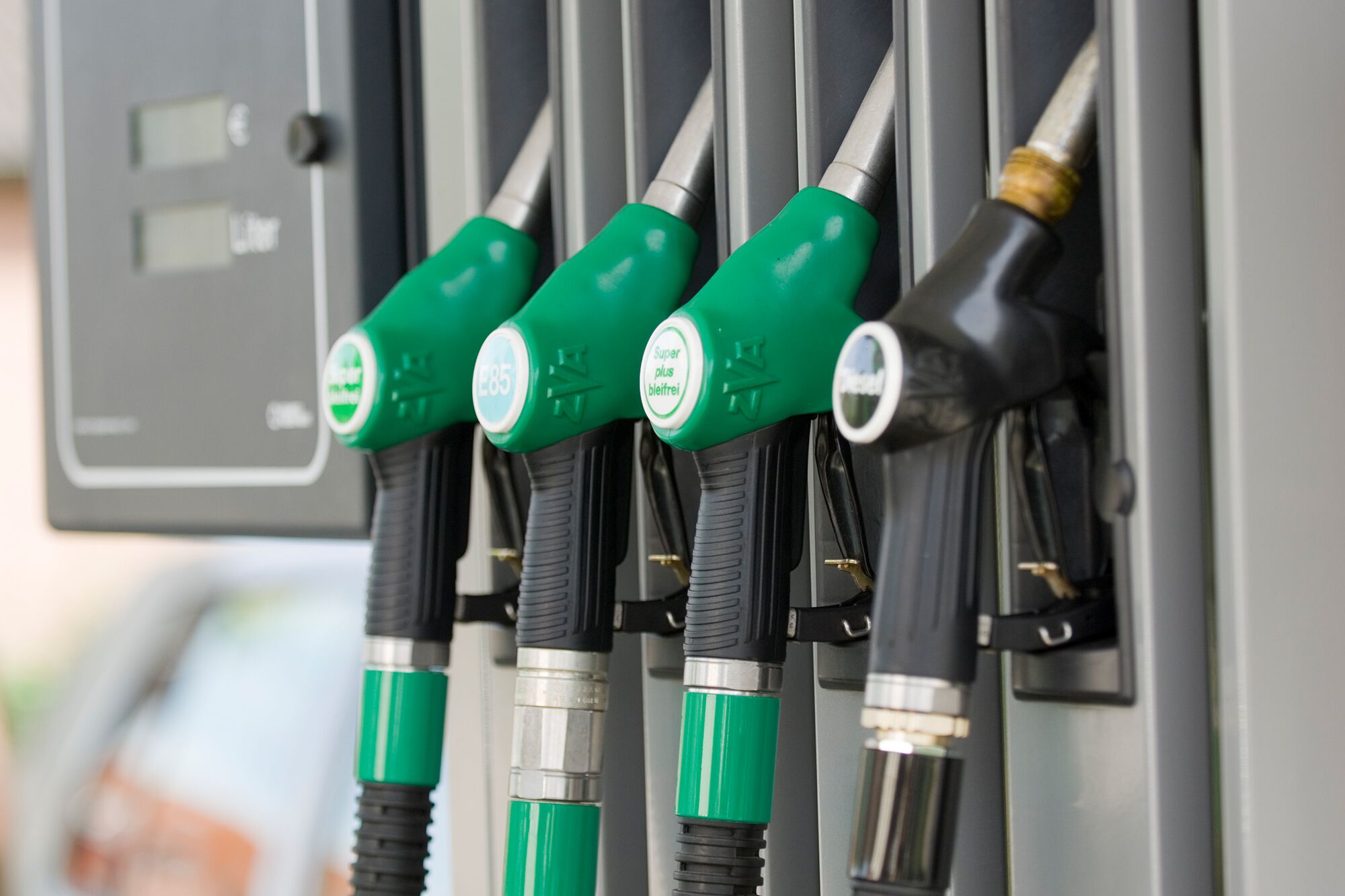 Du siehst Zapfpistolen für Diesel, Super, E85 und Super Plus an einer modernen Tankstelle.