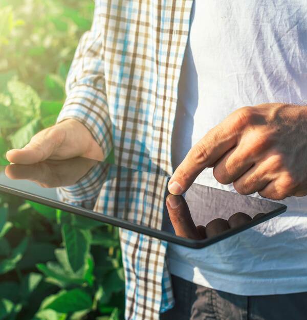 Mann im Feld mit einem Tablet in den Händen