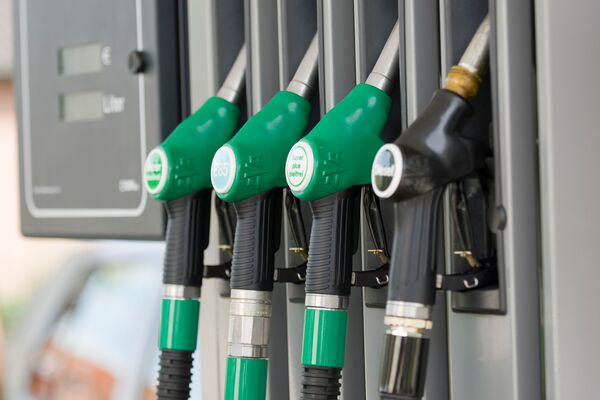 Du siehst Zapfpistolen für Diesel, Super, E85 und Super Plus an einer modernen Tankstelle.